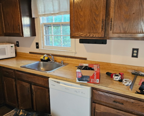 Old kitchen with wooden cabinets and dishwasher before renovation
