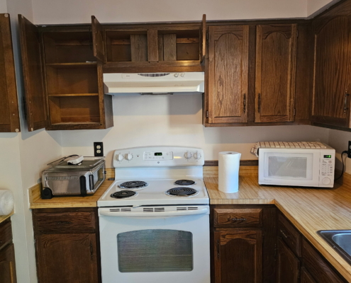 Old kitchen with wooden cabinets and dishwasher before renovation